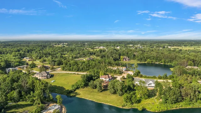 an aerial view of lake residential house with outdoor space and trees around