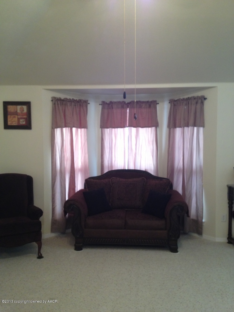 4801 Nimbus Lane Amarillo, TX 79110 - Photo 7 of 40 a blue bed sitting in a bedroom next to a window and a chair