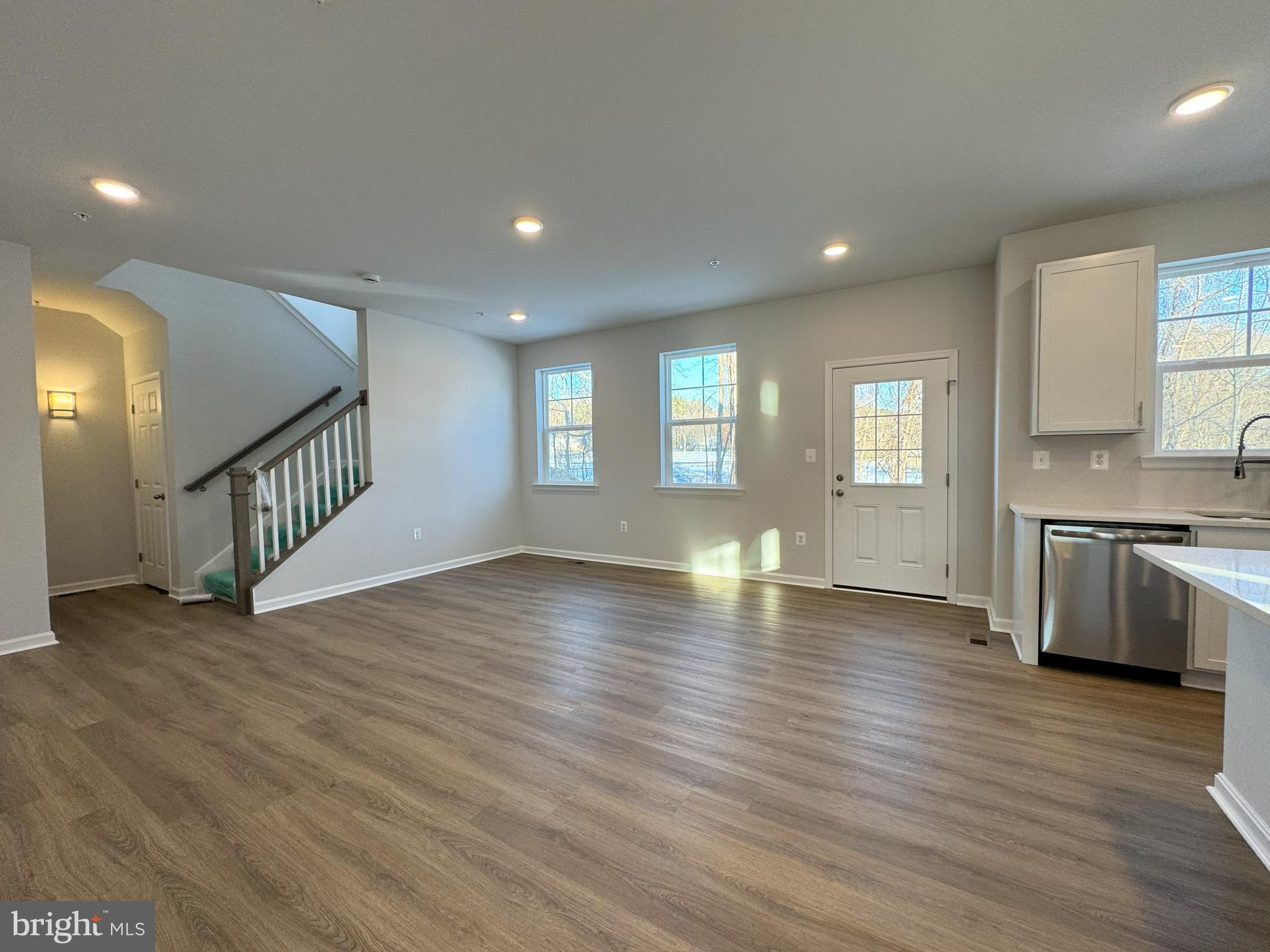 11306 H G Trueman Road Lusby, MD 20657 - Photo 8 of 33 a view of a kitchen and an empty room with wooden floor and a kitchen