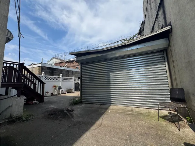 a view of a house with a barbeque and wooden stairs