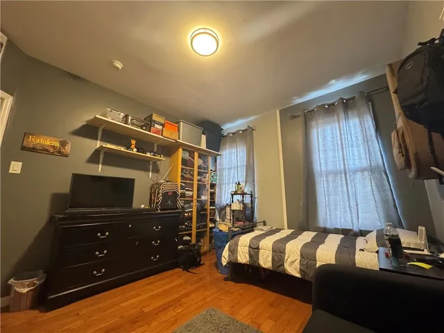 a bedroom with a bed and a flat tv screen on a dresser