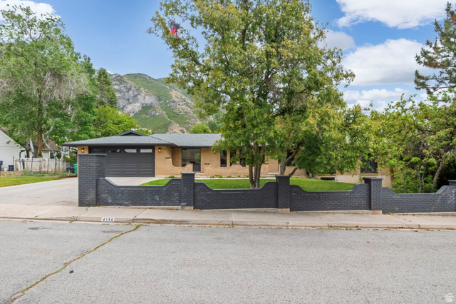 4150 Dover Lane Provo, UT 84604 - Photo 3 of 44 Ranch-style residence featuring a distinctive dark brick privacy wall and an attached garage with a dark panel door