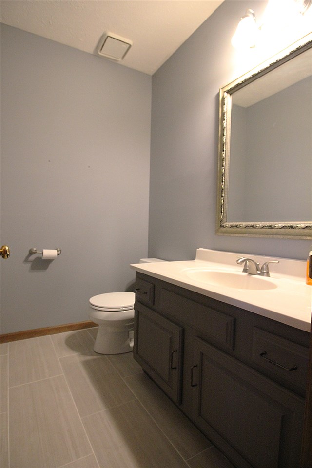 7097 Sentinel Road Rockford, IL 61107 - Photo 12 of 25 a bathroom with a granite countertop toilet a sink and mirror