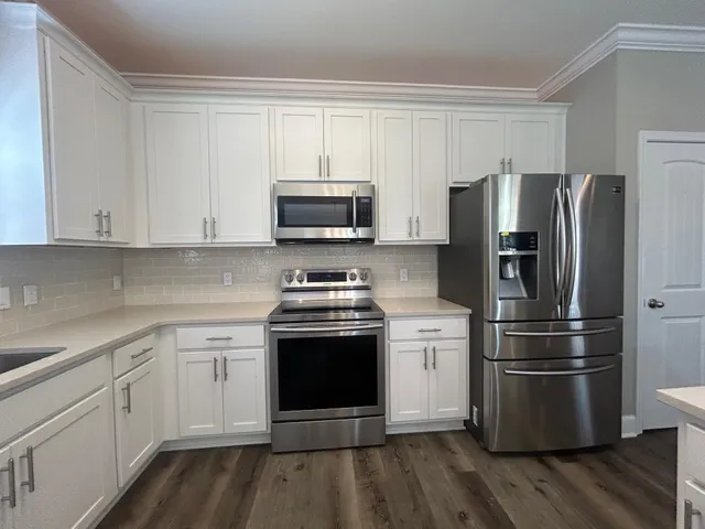 a kitchen with stainless steel appliances a refrigerator stove and microwave
