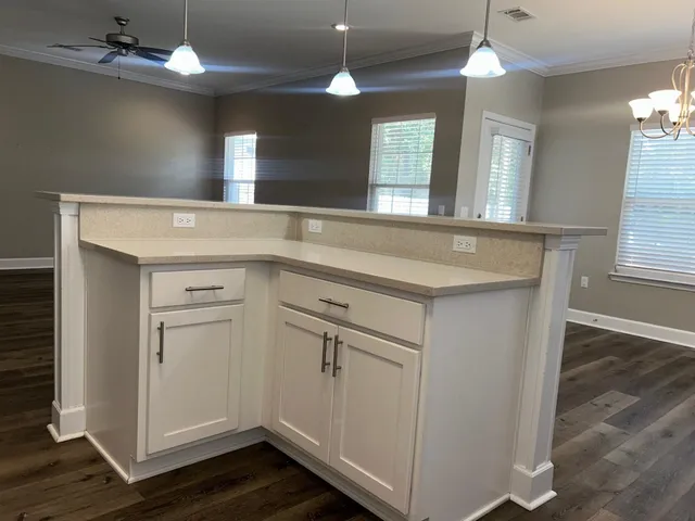 a kitchen with a sink cabinets and chandelier