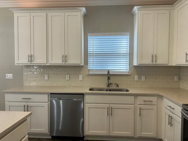 a kitchen with stainless steel appliances granite countertop white cabinets sink and dishwasher