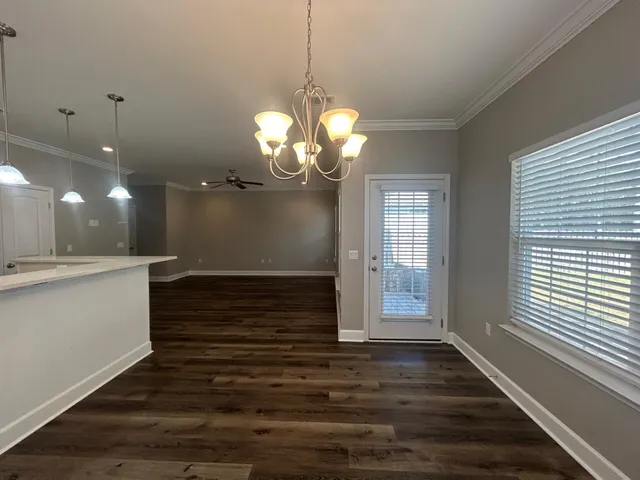 a view of a hallway with wooden floor and a large window
