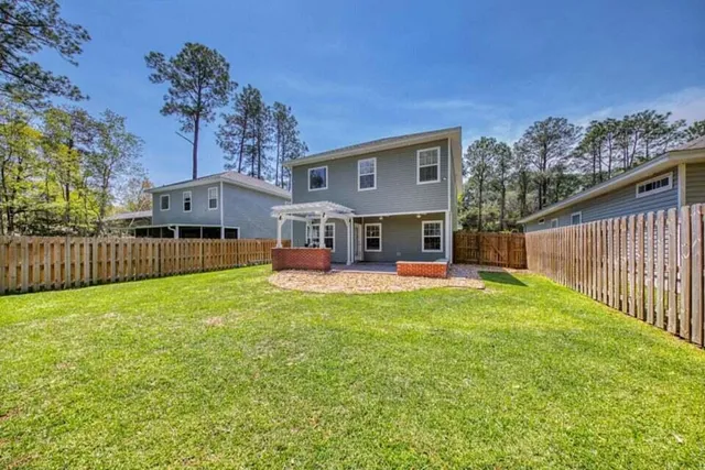 a view of a house with backyard and a tree