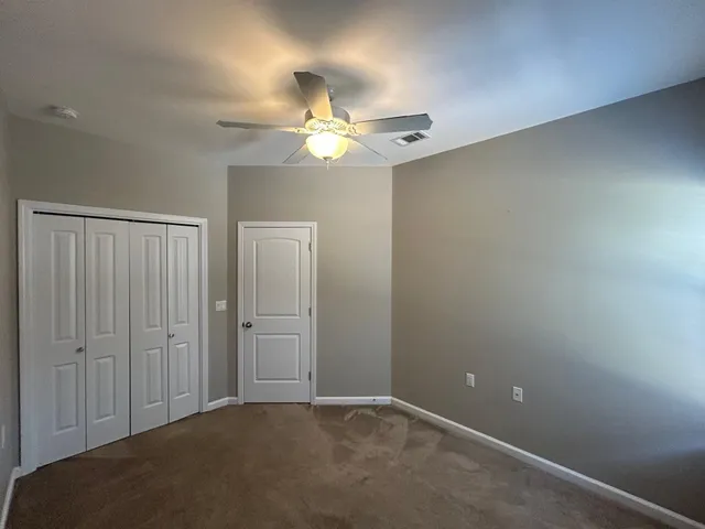 en empty room with windows and fan