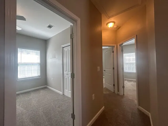 an empty room with closet and ceiling fan