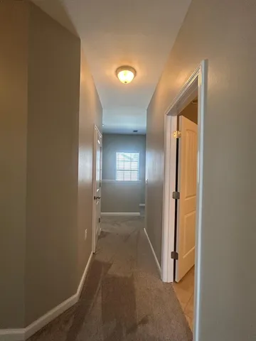 a view of an empty room with a ceiling fan and window