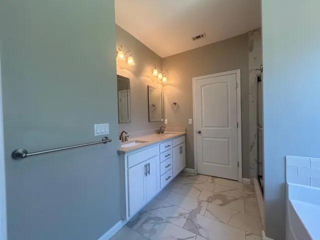 a bathroom with a double vanity sink and a mirror