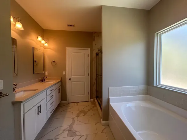 a bathroom with a bathtub and a shower