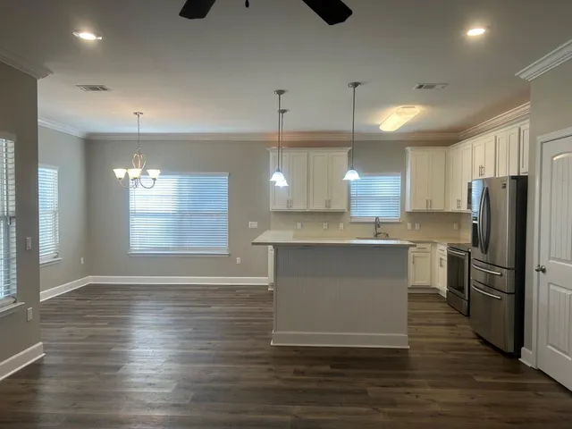 a large kitchen with granite countertop a large counter top stainless steel appliances and cabinets