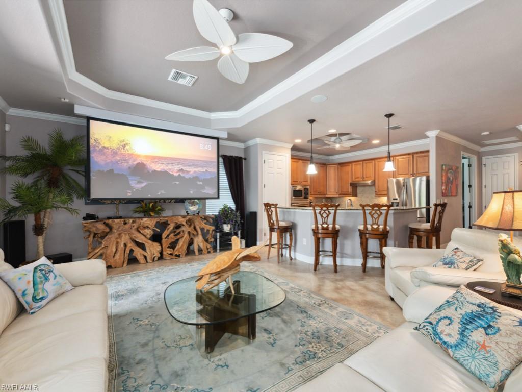 9522 Piacere Way Naples, FL 34113 - Photo 12 of 48 Living room featuring a ceiling fan, visible vents, and ornamental molding