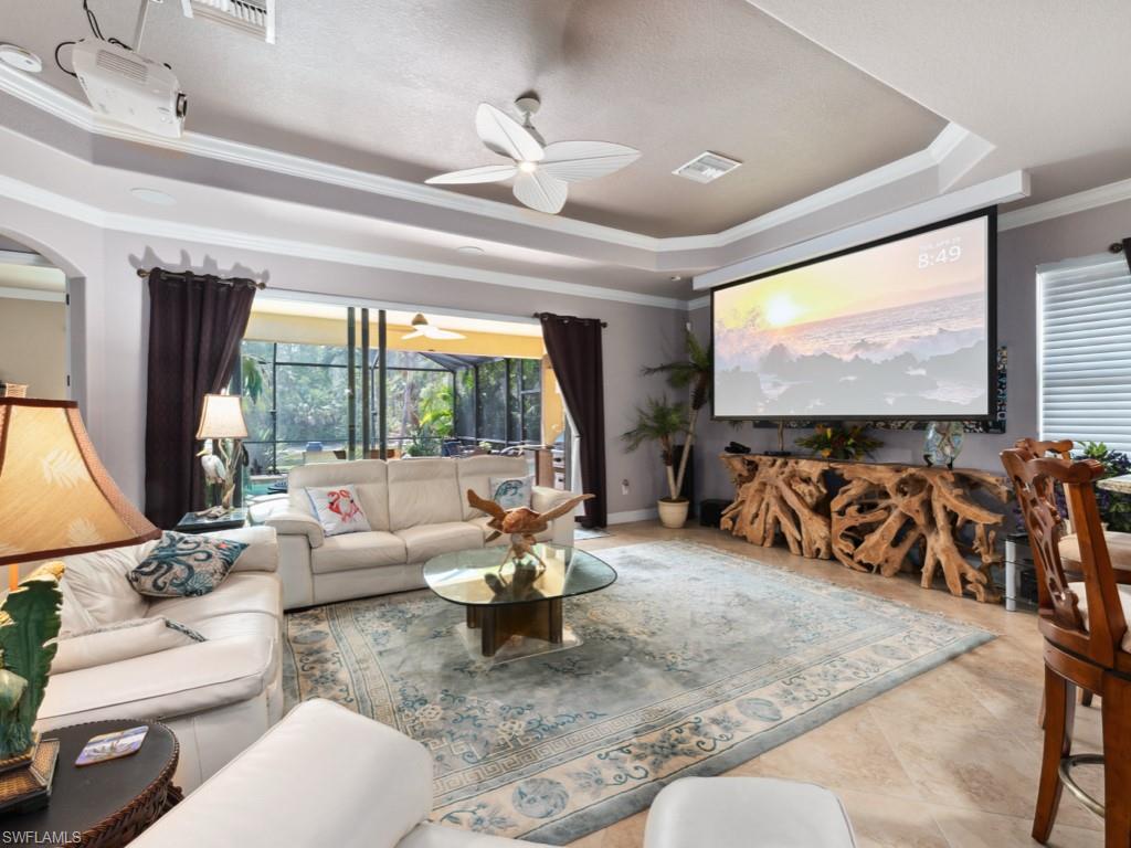 9522 Piacere Way Naples, FL 34113 - Photo 14 of 48 Tiled living room with ceiling fan, visible vents, ornamental molding, and a raised ceiling