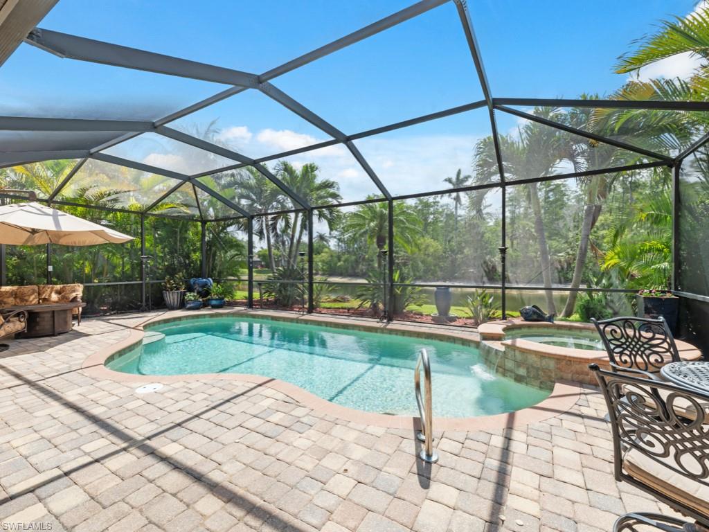 9522 Piacere Way Naples, FL 34113 - Photo 2 of 48 View of pool with glass enclosure, a patio area, and a pool with connected hot tub