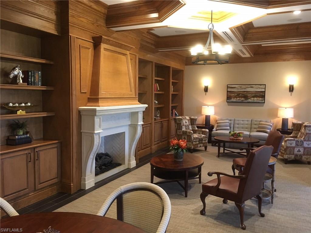 9522 Piacere Way Naples, FL 34113 - Photo 45 of 48 Living area featuring a notable chandelier, built in shelves, ornamental molding, and a fireplace