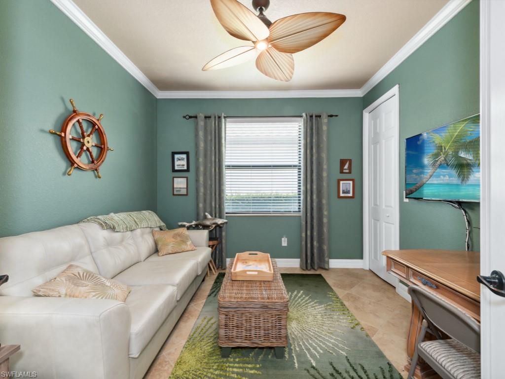 9522 Piacere Way Naples, FL 34113 - Photo 8 of 48 Living room featuring crown molding, baseboards, ceiling fan, and light tile patterned floors