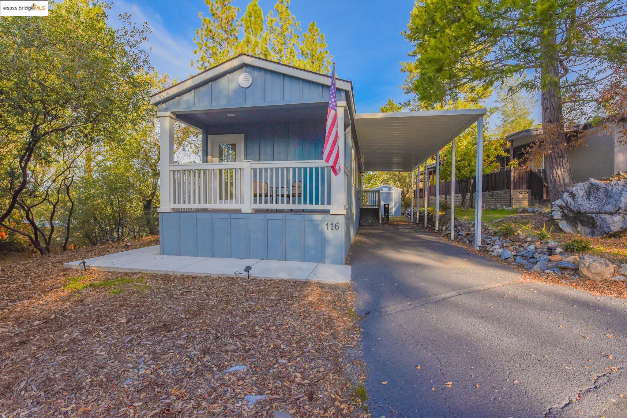 10956 Green Street Columbia, CA 95310 - Photo 34 of 45 Manufactured / mobile home with an attached carport, board and batten siding, a porch, and driveway