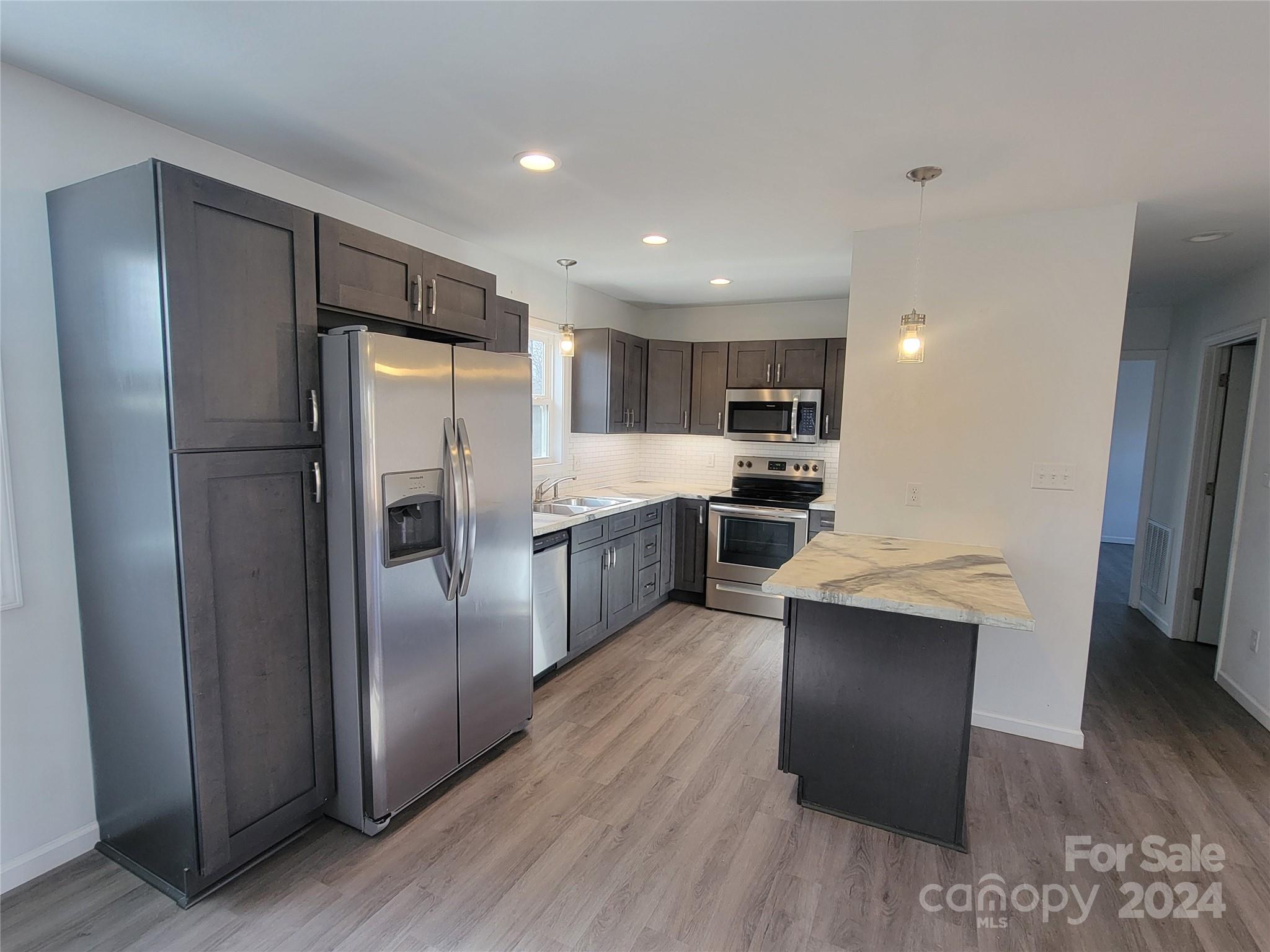 636 Hawthorne Street Hudson, NC 28638 - Photo 7 of 21 a kitchen with stainless steel appliances a refrigerator and a stove top oven