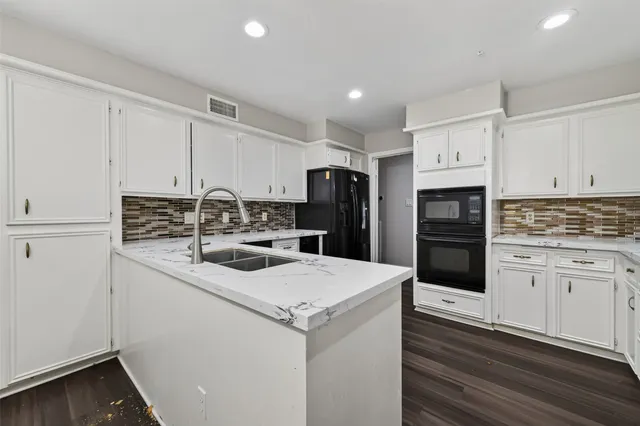 a kitchen with white cabinets sink and stainless steel appliances