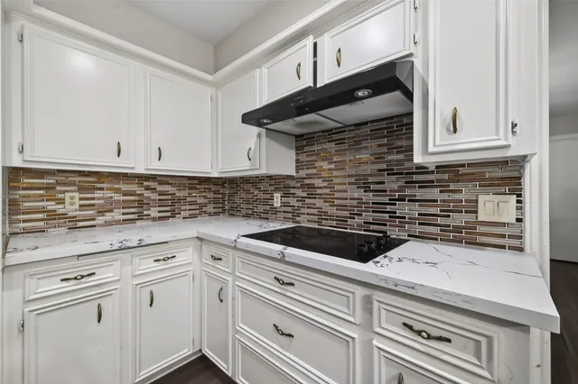 a kitchen with granite countertop white cabinets and white appliances