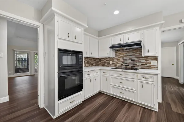 a kitchen with granite countertop white cabinets and stainless steel appliances