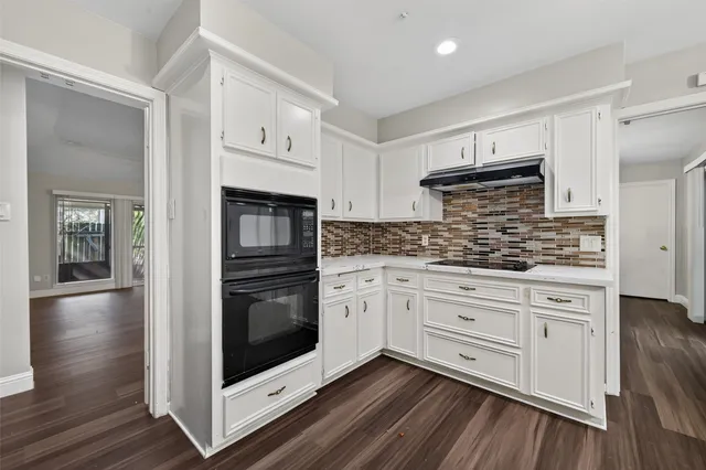 a kitchen with granite countertop white cabinets and stainless steel appliances