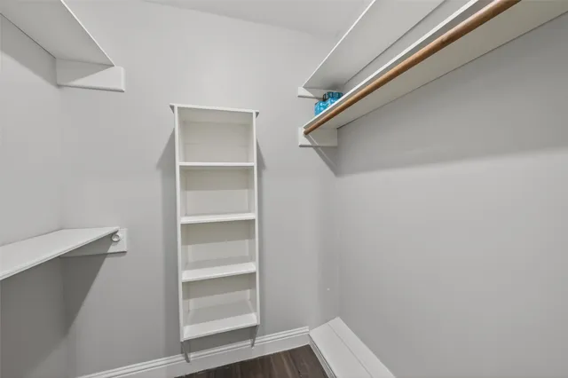 a view of walk in closet with empty racks