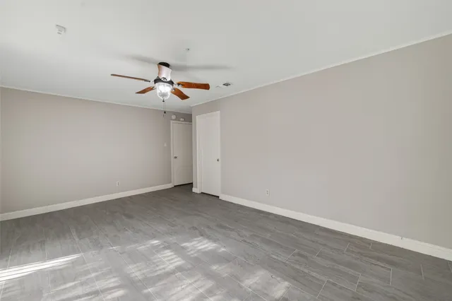 a view of an empty room with a ceiling fan