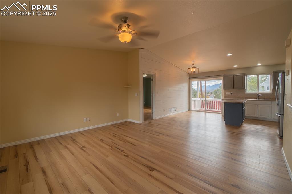 863 Circle Road Palmer Lake, CO 80133 - Photo 17 of 48 a view of an empty room with a kitchen and wooden floor