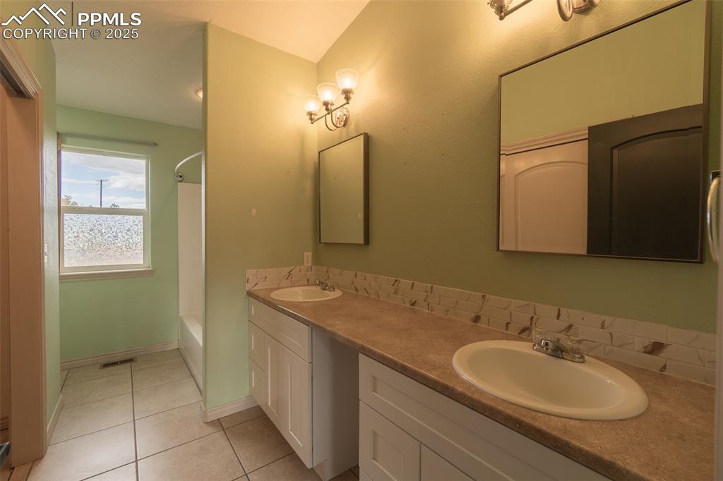 863 Circle Road Palmer Lake, CO 80133 - Photo 26 of 48 a bathroom with a sink and a mirror