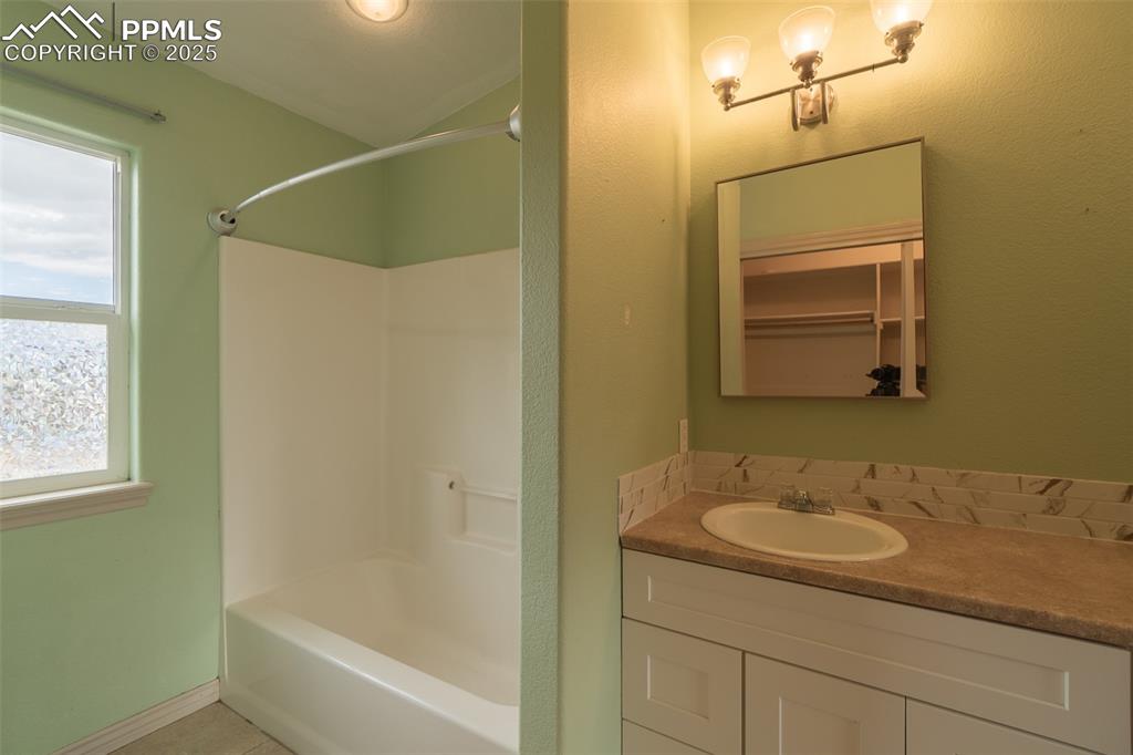 863 Circle Road Palmer Lake, CO 80133 - Photo 27 of 48 a bathroom with a granite countertop sink a mirror and a bathtub