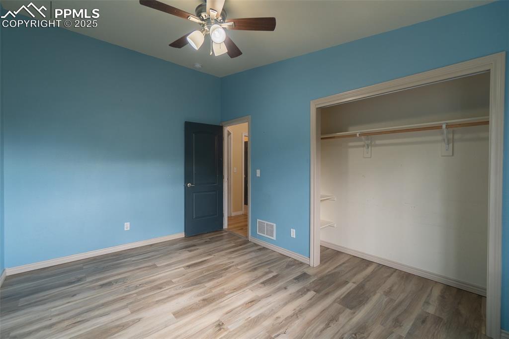 863 Circle Road Palmer Lake, CO 80133 - Photo 28 of 48 an empty room with wooden floor and fan