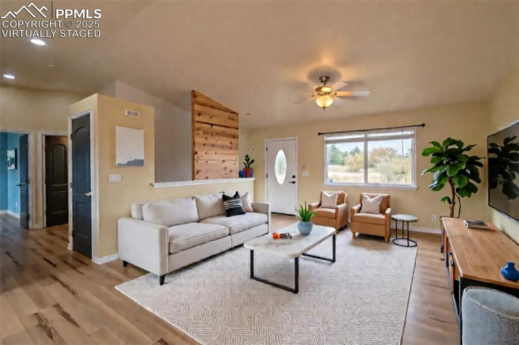 863 Circle Road Palmer Lake, CO 80133 - Photo 3 of 48 a living room with furniture ceiling fan and a window