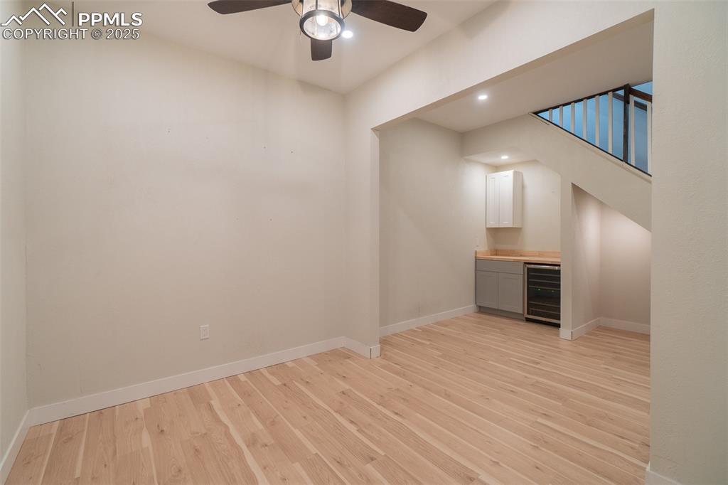 863 Circle Road Palmer Lake, CO 80133 - Photo 36 of 48 an empty room with wooden floor kitchen view and windows