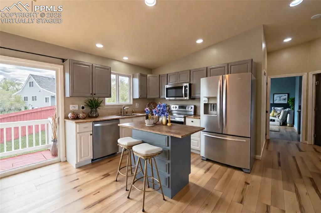 863 Circle Road Palmer Lake, CO 80133 - Photo 4 of 48 a kitchen with kitchen island wooden floors white appliances a center island and furniture
