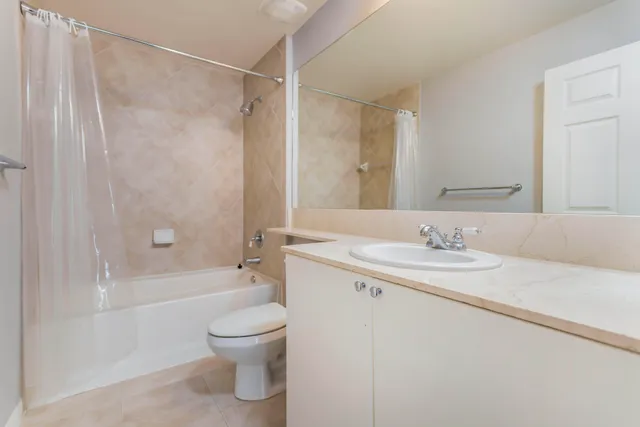 a bathroom with a granite countertop sink a toilet and shower
