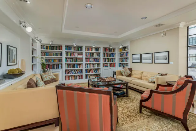 a living room with furniture a rug and a book shelf