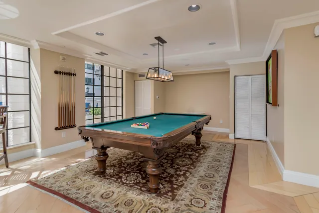 a room with pool table and windows