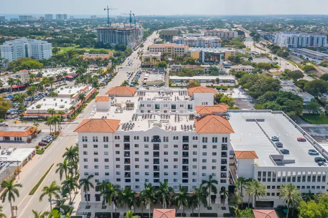 an aerial view of a city with lots of residential buildings ocean and mountain view in back