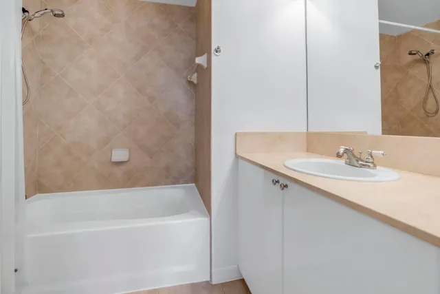a view of an empty room with wooden floor and a chandelier