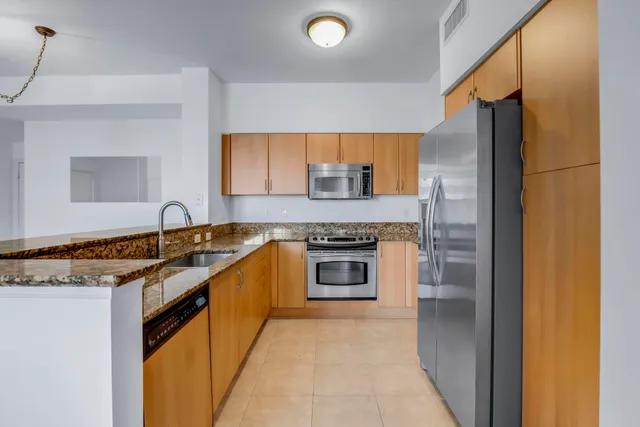 a kitchen with stainless steel appliances granite countertop a stove and a refrigerator