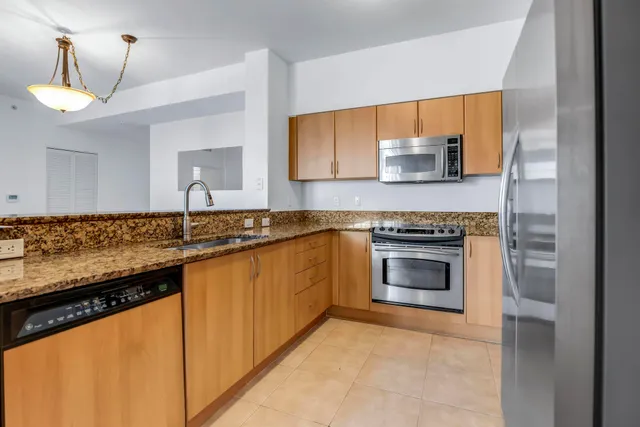 a kitchen with granite countertop a sink and a stove top oven
