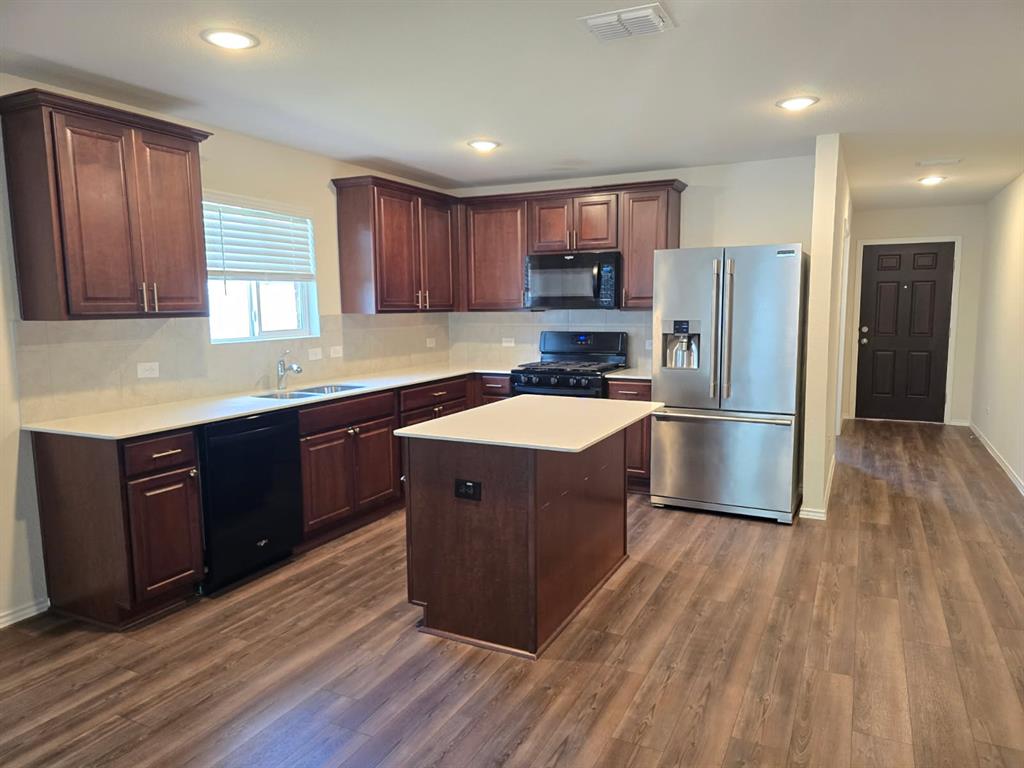 16029 Pemberly Lane Haslet, TX 76052 - Photo 2 of 19 a kitchen with wooden floors stainless steel appliances a sink and a window