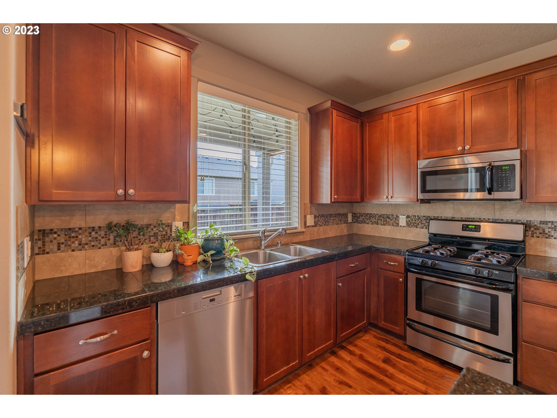 522 North 40th Avenue Ridgefield, WA 98642 - Photo 6 of 32 a kitchen with stainless steel appliances granite countertop wooden cabinets a stove top oven with a sink and dishwasher