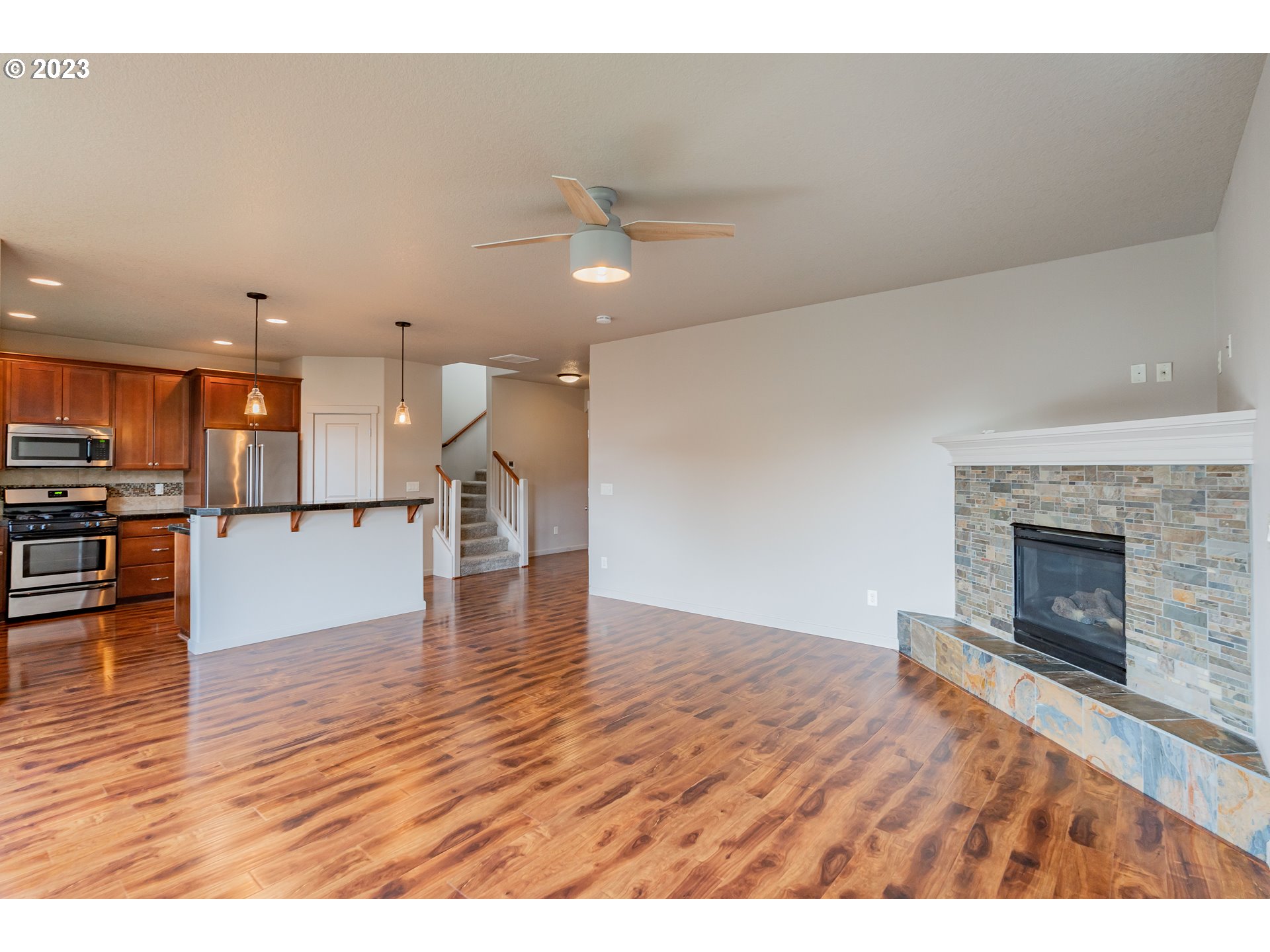 522 North 40th Avenue Ridgefield, WA 98642 - Photo 10 of 32 a view of a kitchen and an empty room with wooden floor