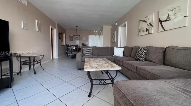 a living room with furniture and a dining table with kitchen view