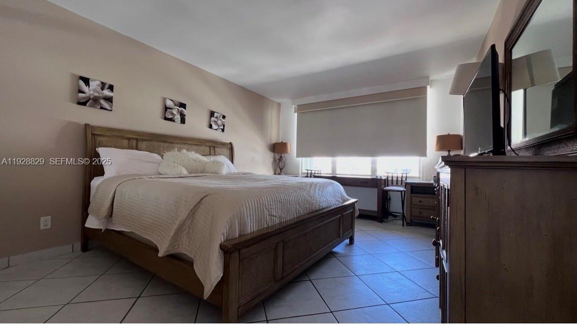 5161 Collins Avenue, Unit 1701 Miami Beach, FL 33140 - Photo 7 of 17 a bed room with a bed and a television